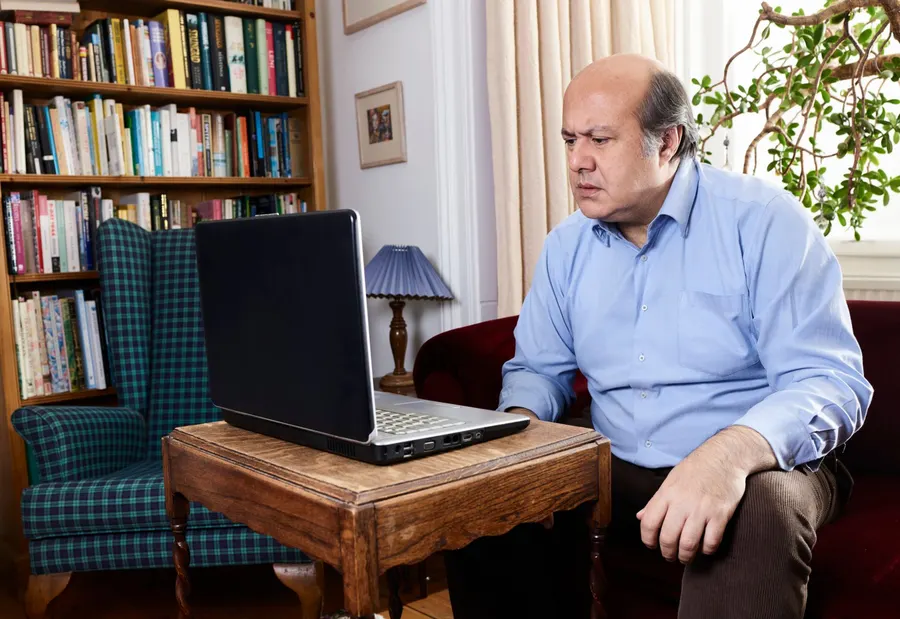 شخص بالغ يستخدم جهاز كمبيوتر في مكان مريح